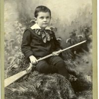 Portrait of a young boy holding a gun.