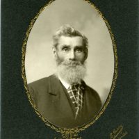 Portrait of man with a white beard wearing suit.