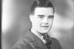 Film negative of a man in an RCAF Uniform. The man has dark hair an  an eagle badge on his right shoulder. The negative was located In a folder with 3 other negatives labelled "HE-2876 China", all of different men.