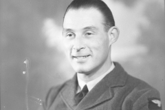 Film negative of a man in an RCAF Uniform. The man has dark hair an  an eagle badge on his left shoulder. The negative was located In a folder with 3 other negatives labelled "HE-2876 China", all of different men.